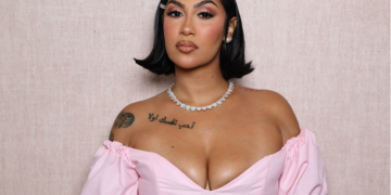 A photo of R&B singer Queen Naija wearing a pink outfit